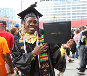 Kye Adams holds their diploma cover at City Colleges of Chicago's 2023 Commencement Ceremony for associate degree earners.