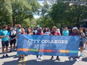 City Colleges community members carry the CCC banner.